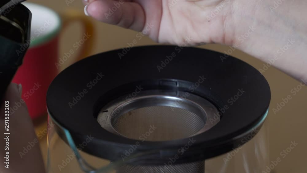 Fill up a teapot with herbs with a spoon to make tea. Preparation of a hot drink. Fill up a teapot with herbs with a spoon to make tea. Preparation of a hot drink.
