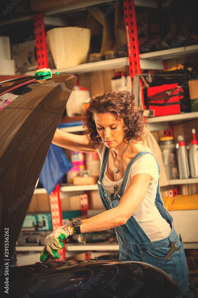 Beautiful woman automechanic in blue overall