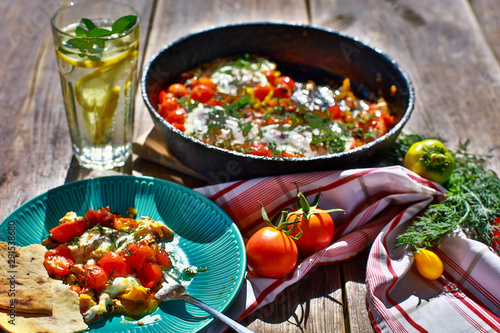 fried eggs with vegetables in a pan