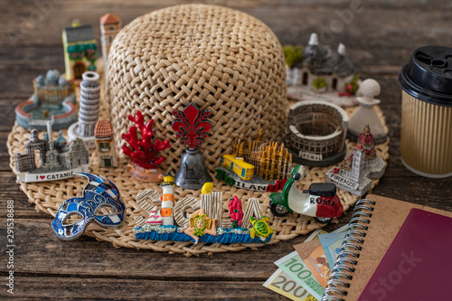 Many souvenirs from Italy on the wooden table, vacation concept with money. photo