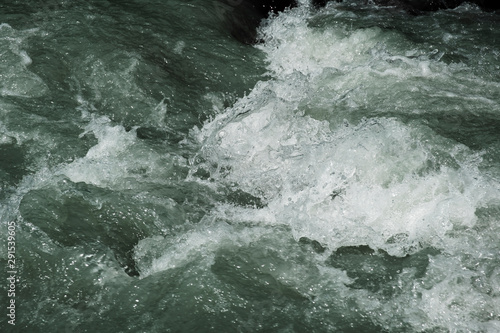 The surface of the stormy water. Mountain river. Foam on the crest of a wave.