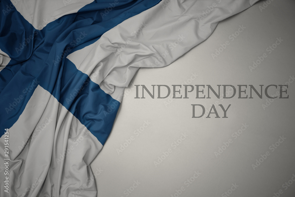 waving colorful national flag of finland on a gray background with text independence day. waving colorful national flag of finland on a gray background with text independence day.