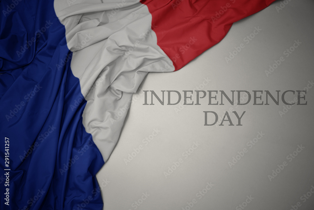 waving colorful national flag of france on a gray background with text independence day.