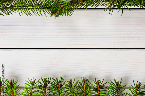 Christmas frame with fir branches on white wooden background, copy space image