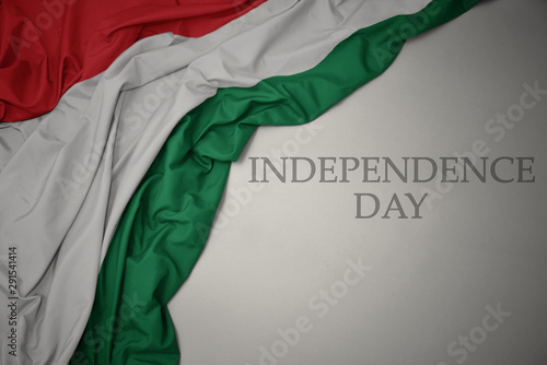 waving colorful national flag of hungary on a gray background with text independence day.