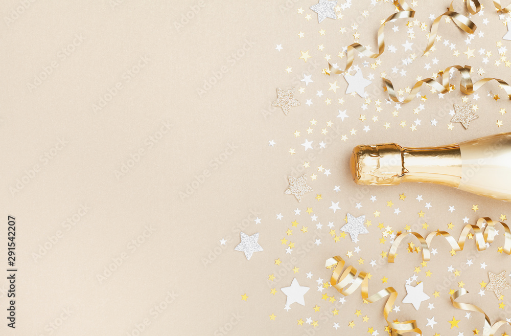Golden champagne bottle with confetti stars and party streamers top