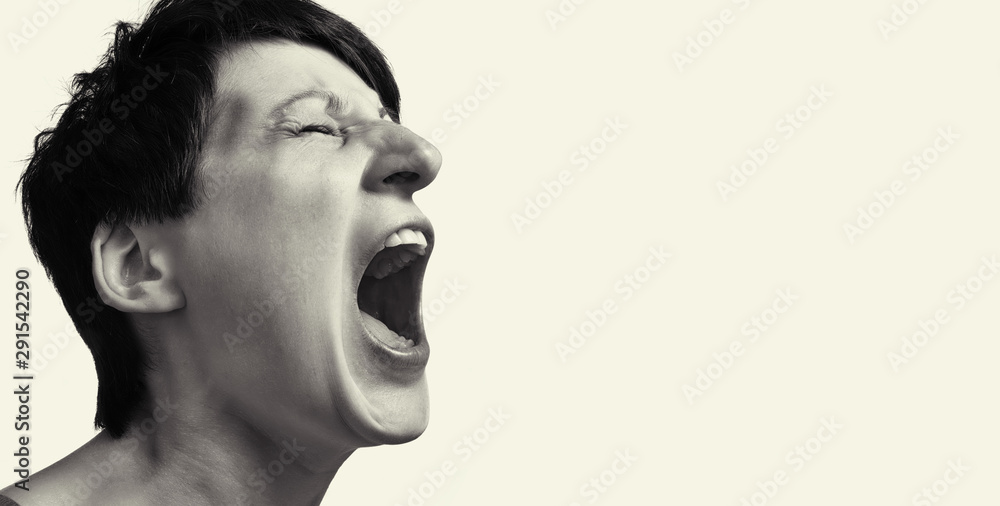 Concept of anger. Portrait of a screaming woman on isolated background with free space. Black and white image. Concept of anger. Portrait of a screaming woman on isolated background with free space. Black and white image.