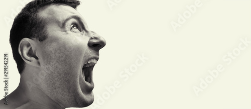Concept of anger. Portrait of a screaming man on isolated background with free space. Black and white image. © svetazi