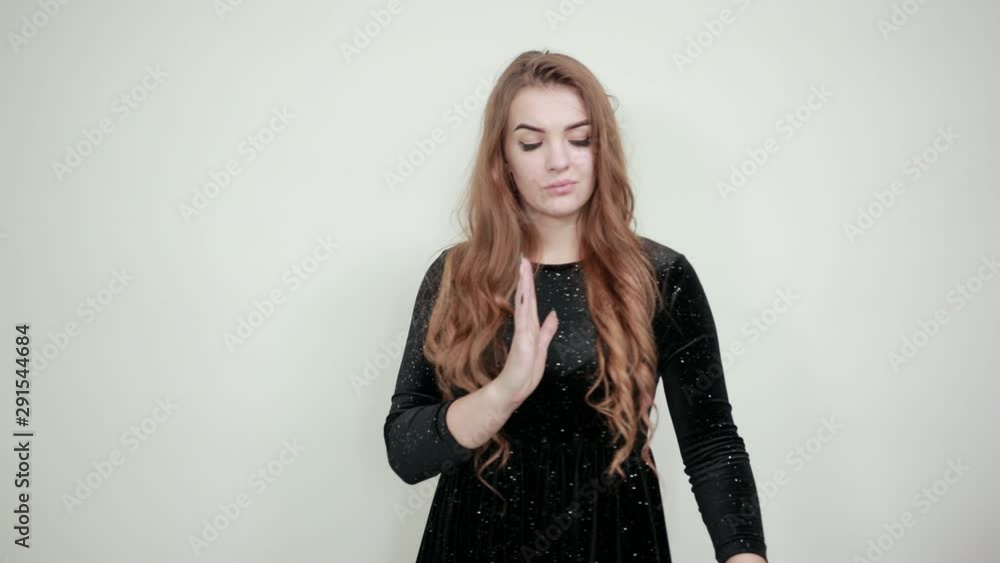 girl brown haired in black dress over isolated white background shows emotions girl brown haired in black dress over isolated white background shows emotions