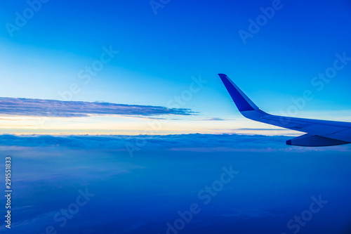 View of plane wing and beautiful sky above the clouds from plane 