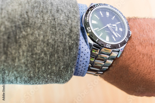 man's arm showing steel watch with shirt and jacket