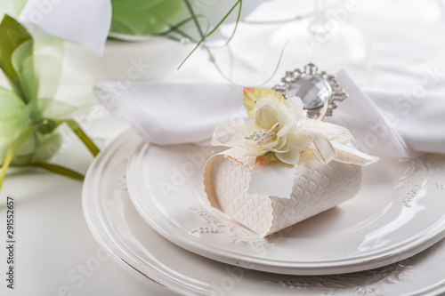 Festive table setting with small gift on plate