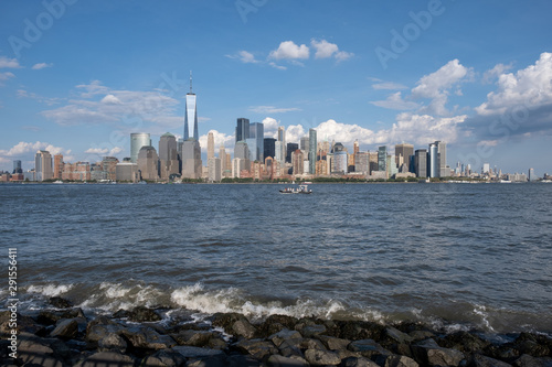 Lower Manhattan skyline with boat and ferry on Hudson river view from Liberty State Park in late summer