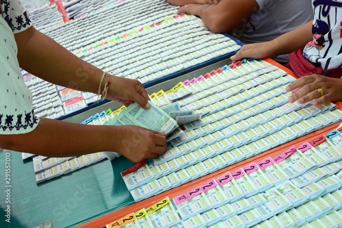 a hand of woman choose the lotto from plastic panel with many of lottery