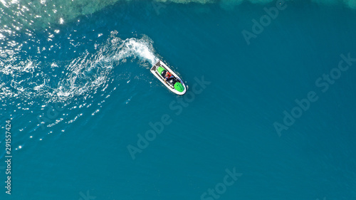 Aerial drone top down photo of jet ski watercraft cruising in high speed in tropical exotic lake