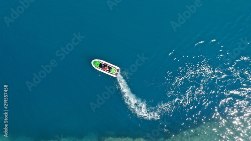 Aerial drone top down photo of jet ski watercraft cruising in high speed in tropical exotic lake