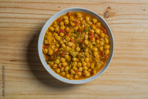 Cooked chickpea with vegetables isolated in a wooden table