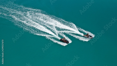 Aerial drone top down photo of 2 men operating jet ski watercraft cruising in high speed in tropical exotic lake © aerial-drone