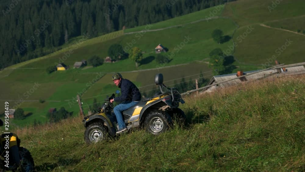 ATV riders in helmets driving quad bikes in mountain. ATV quad biking on summer sunny day. Weekend with the best friends. ATV riders in helmets driving quad bikes in mountain. ATV quad biking on summer sunny day. Weekend with the best friends.