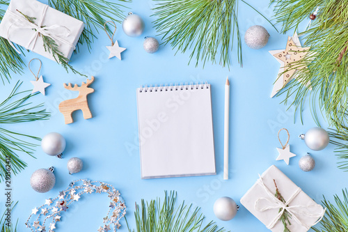 Mockup white notebook with pine branches and christmas decorations on a blue background