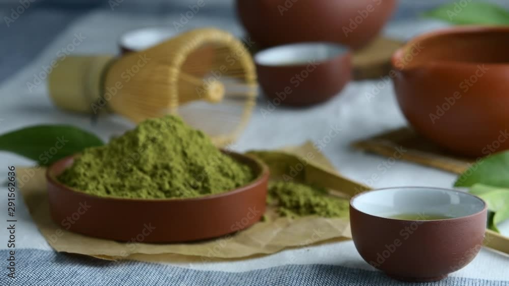 Green tea powder with leaf in ceramic dish on the table, Japanese wire whisk made of bamboo for matcha tea ceremony. Green tea powder with leaf in ceramic dish on the table, Japanese wire whisk made of bamboo for matcha tea ceremony.
