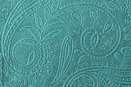 Texture of genuine leather with embossed floral trend pattern close-up, green mint color, for wallpaper or banner design. For modern background photo