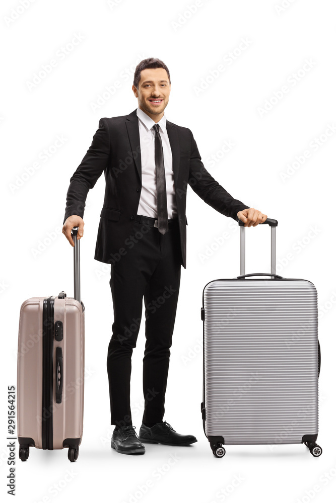 Man in a suit posing with two suitcases Man in a suit posing with two suitcases