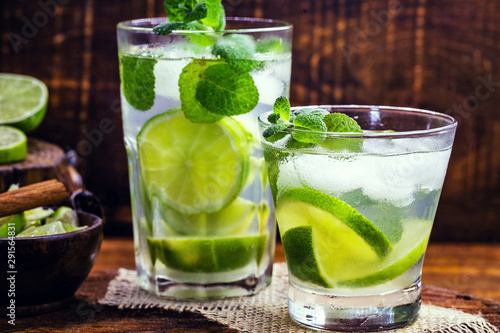 Mojito is a white rum-based cocktail made in Cuba. Tourist drink created in Havana. alcoholic drink on rustic wood background, image for menu or restaurant.