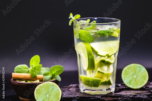 Refreshing summer cold lemonade mojito in a glass on a black background. Tourist drink, menu or restaurant image. Typical summer tourist drink.