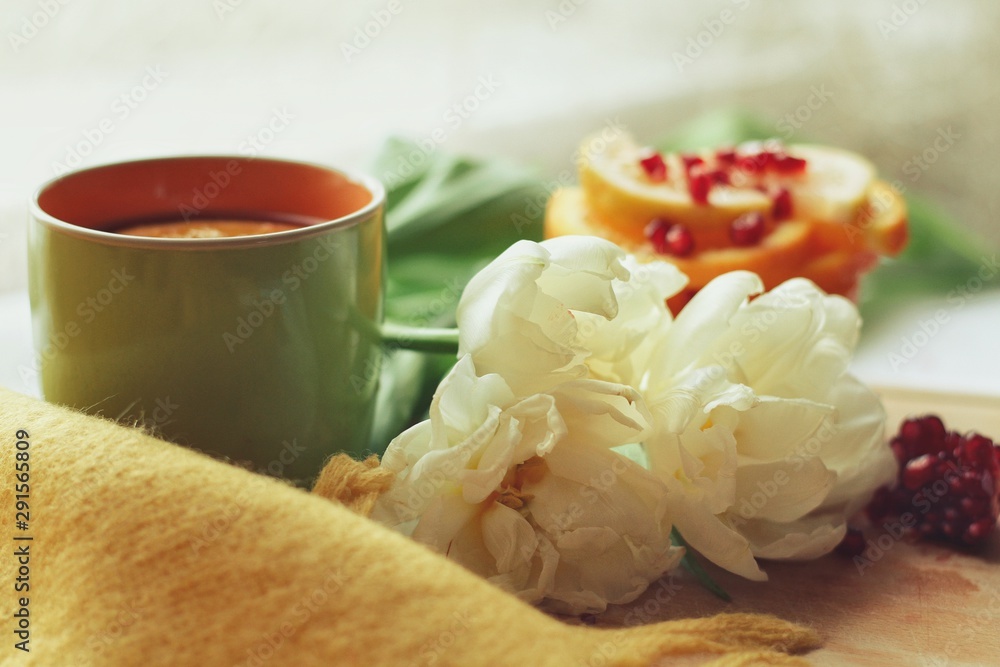 Tender white flower and cup of tea with pomegranate