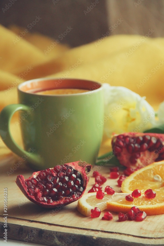 Tender white flower and cup of tea with pomegranate