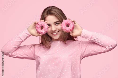 Happy teen girl demonstrating donuts in morning