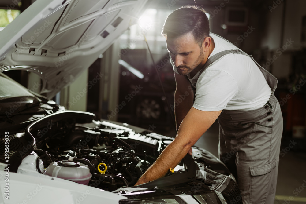 Mechanic working on a car in auto repair shop Mechanic working on a car in auto repair shop