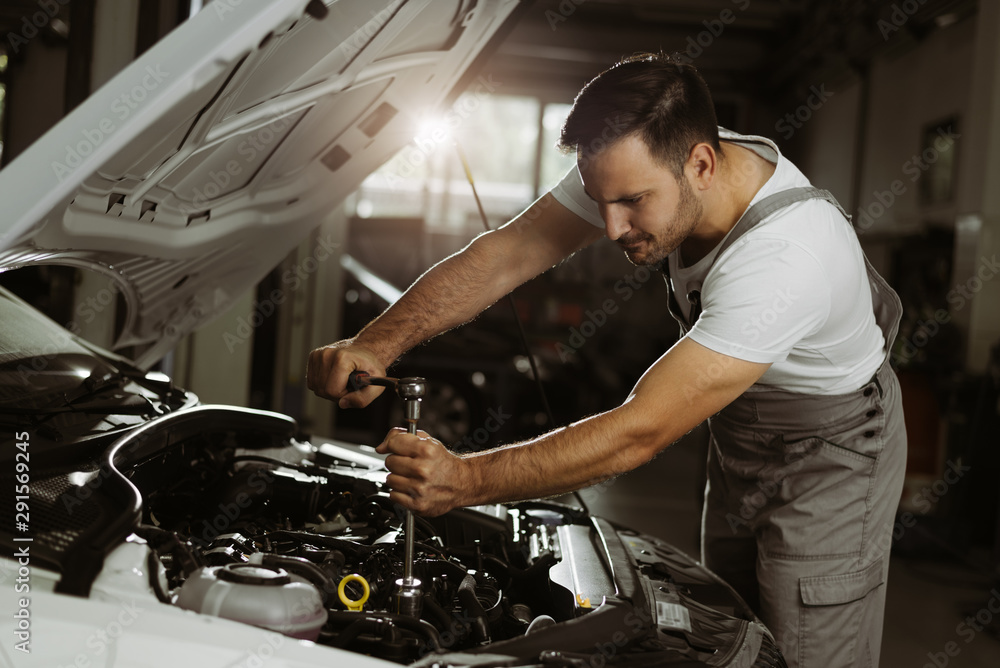 Mechanic is repairing an engine in the auto repair shop Mechanic is repairing an engine in the auto repair shop