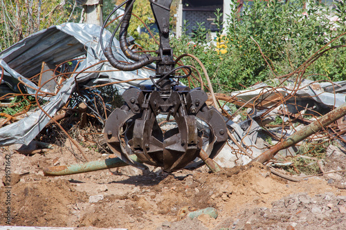 Mechanical grabbing arm manipulator on construction site for the removal of construction waste. A mechanical arm for moving goods.