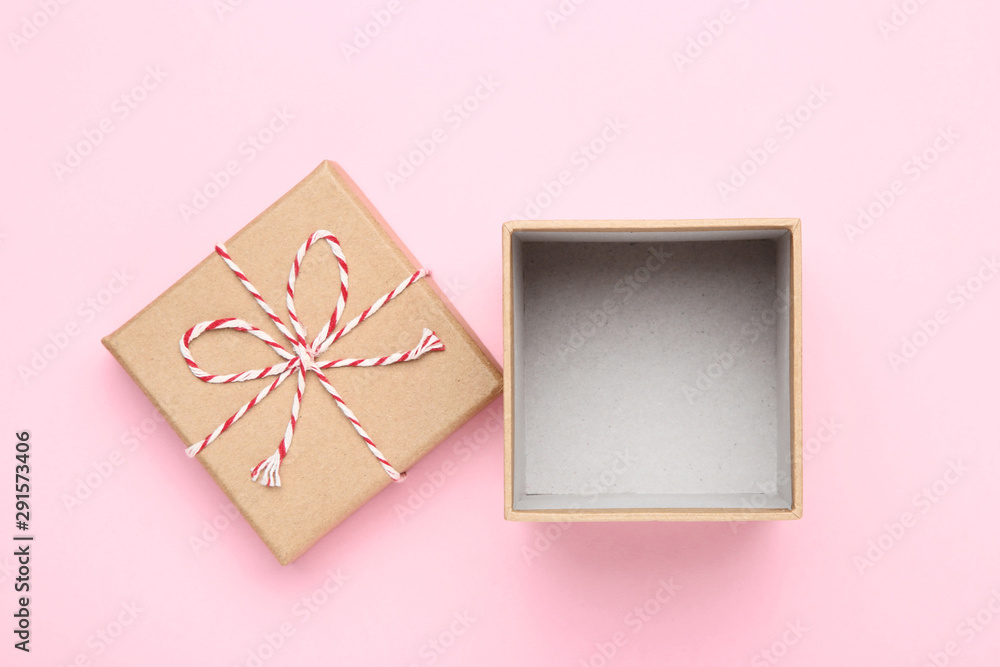 Open brown gift box with rope on pink background