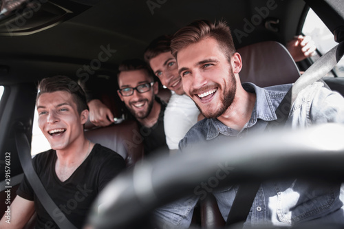 Group of happy friends on a car