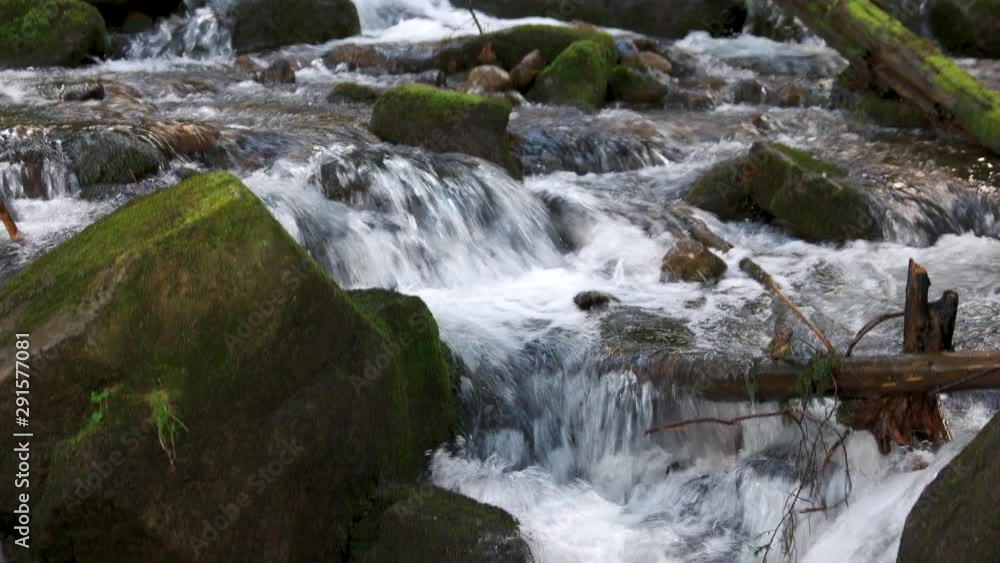 Mountain river streaming among stones. Forest stream among rocks. Beautiful natural background. Mountain river streaming among stones. Forest stream among rocks. Beautiful natural background.
