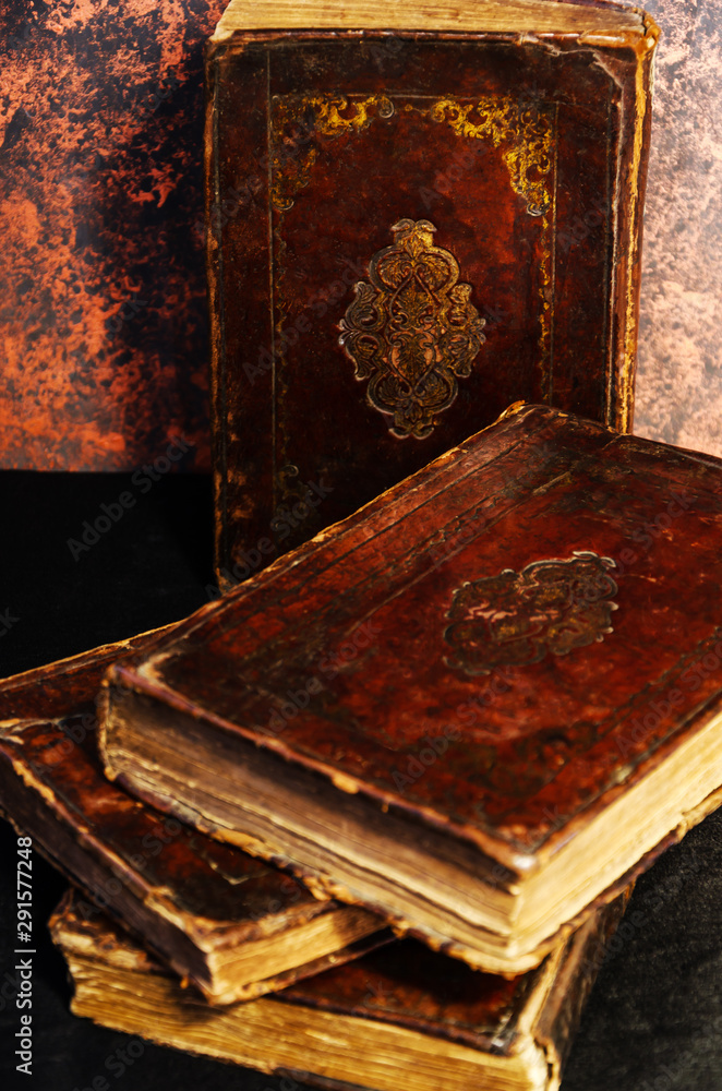 A stack of old leather-bound Jewish books with gold stamping on black background
