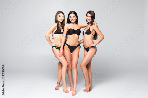 Three beautiful joyful women in bikini isolated on white background