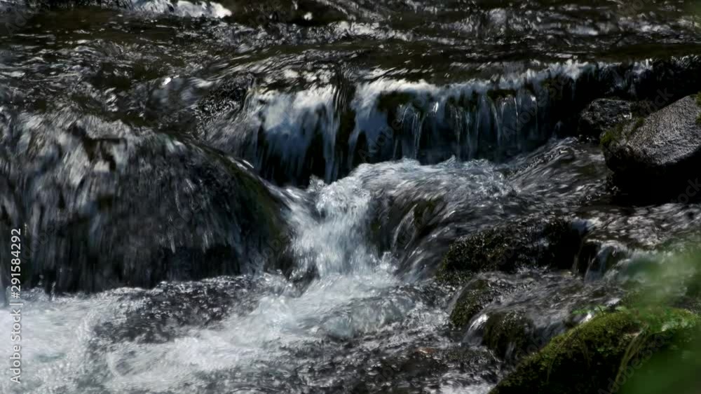 Fast mountain river flowing over stones close up. Stream of crystal cold water over rocks. Fast mountain river flowing over stones close up. Stream of crystal cold water over rocks.
