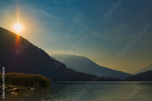 Sonnenuntergang über den Bergen an einem See photo