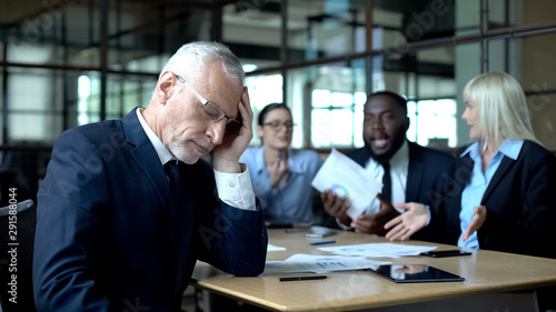 Fotografija Senior manager feeling tired of arguing colleagues office, work stress, burnout