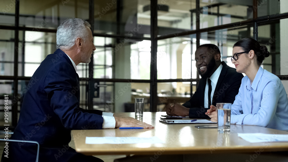Friendly business partners having meeting in office, project negotiation Friendly business partners having meeting in office, project negotiation