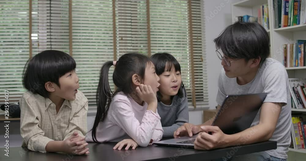 Teacher showing students information on a laptop during a tech lesson. Education and Technology Concept. Teacher showing students information on a laptop during a tech lesson. Education and Technology Concept.
