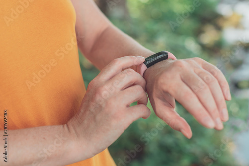 Female hiker using smart wristband during trekking in nature