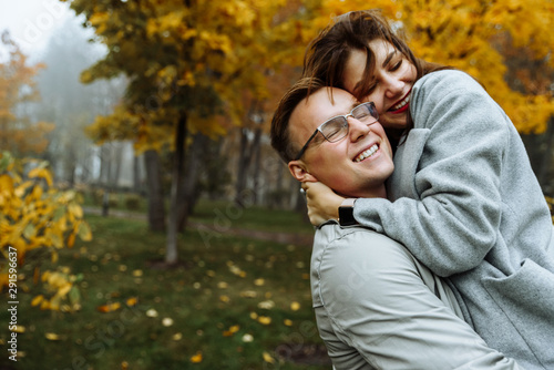 Loving couple in stylish casual wear hugs in the park in the autumn season. Autumn. Golden autumn. Golden leaves..