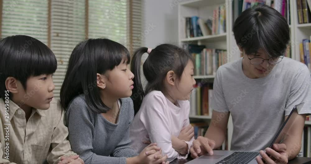 Teacher showing students information on a laptop during a tech lesson. Education and Technology Concept. Teacher showing students information on a laptop during a tech lesson. Education and Technology Concept.