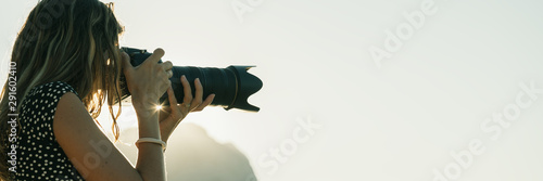 Foto Professional female photographer with zoom lens taking a photo