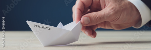 Paper made origami boat with Persistence sign